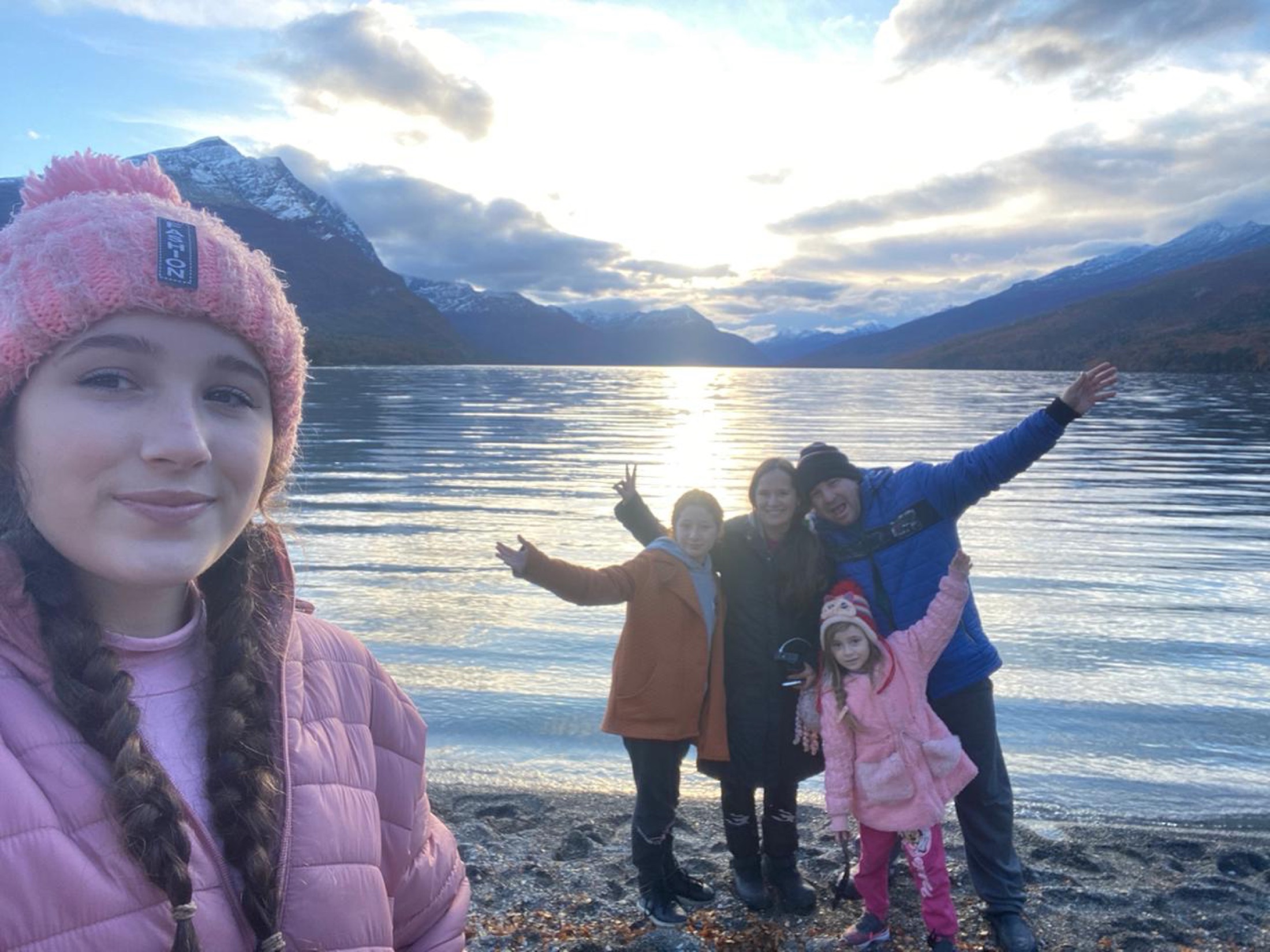 Família Sonhando Mundo Afora diante de um lago entre montanhas